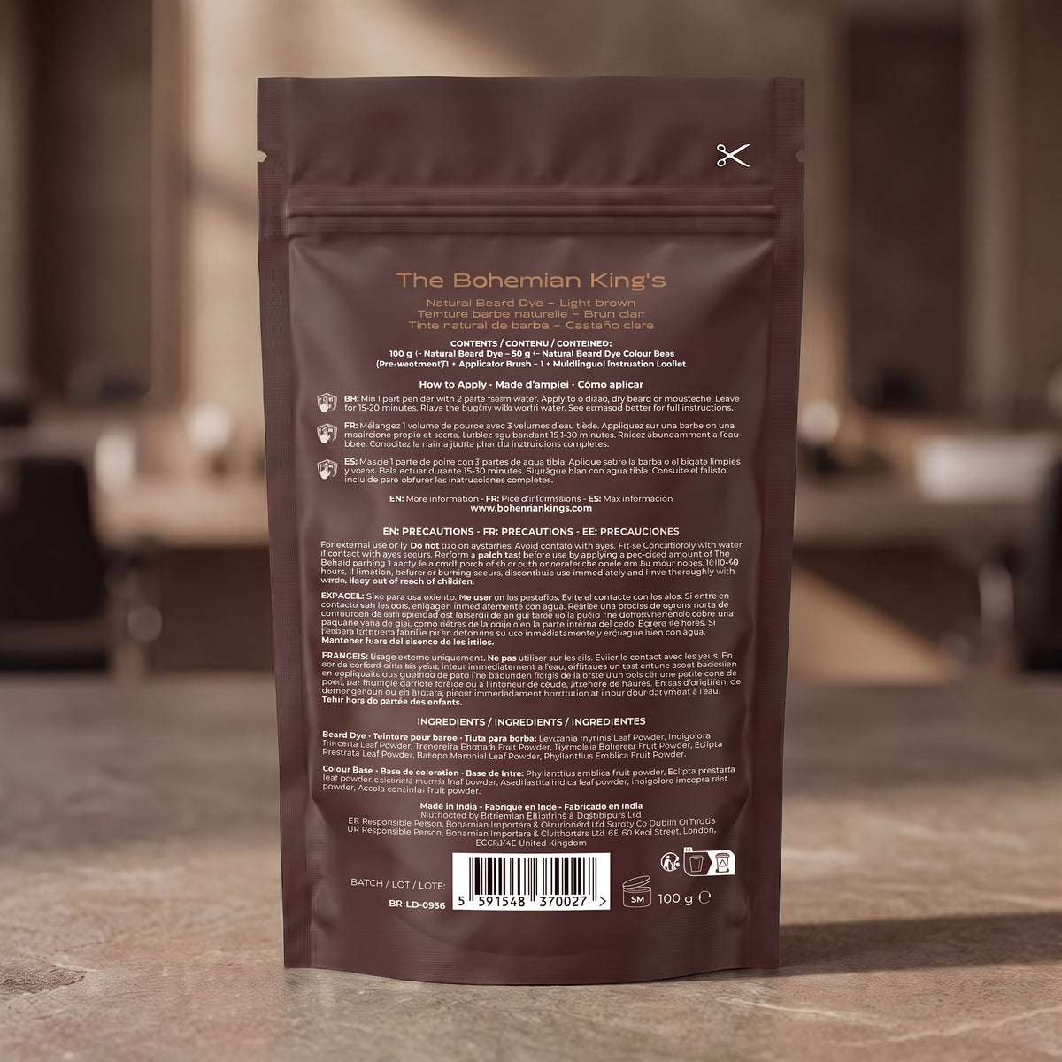 The back of a brown stand-up pouch package for The Bohemian King's Natural Beard Oil, photographed standing upright on a stone countertop with a blurred kitchen background.