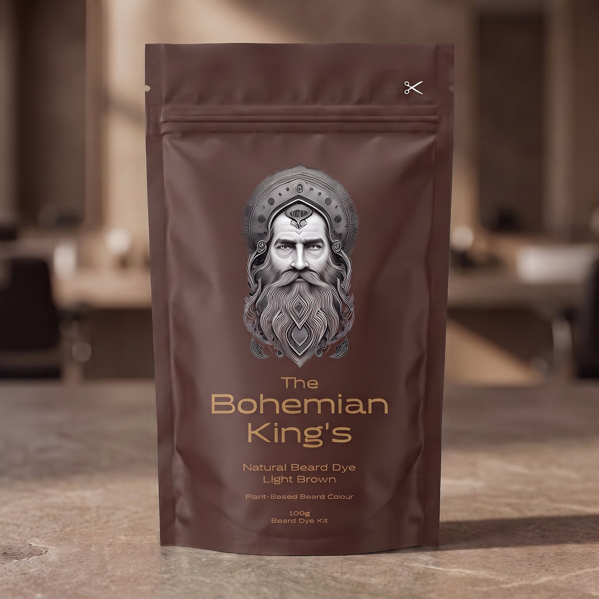 A stand-up pouch of beard dye standing on a stone-like surface with a blurred indoor background. The pouch is dark brown with a large illustrated face and the text 'The Bohemian King's Natural Beard Dye Light Brown' on the front.